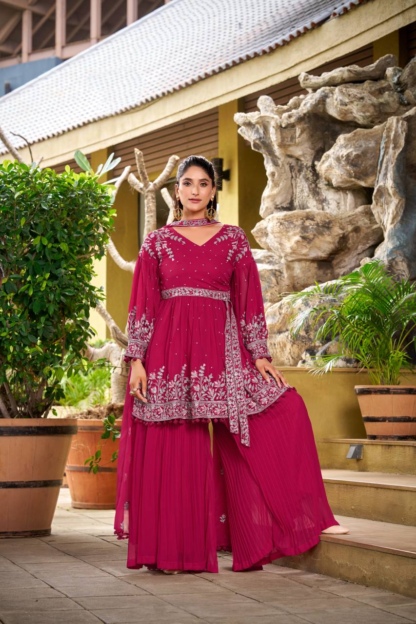 Model wearing deep pink peplum palazzo set with puffed full sleeves and V-neckline.